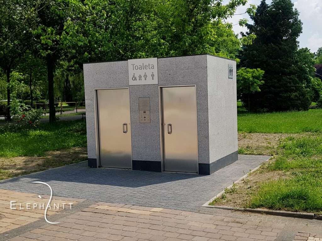 Automatyczna dwustanowiskowa prostokątna toaleta miejska w na terenie Parku Hallera w Dąbrowie Górniczej.