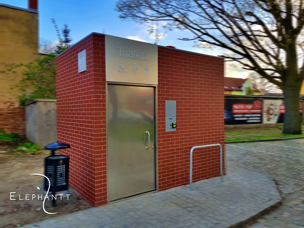 Automatyczna jednostanowiskowa prostokątna toaleta miejska City S1 we Wschowie przy ul. Poprzecznej. Elewacja wykonana z płytek gresowych.